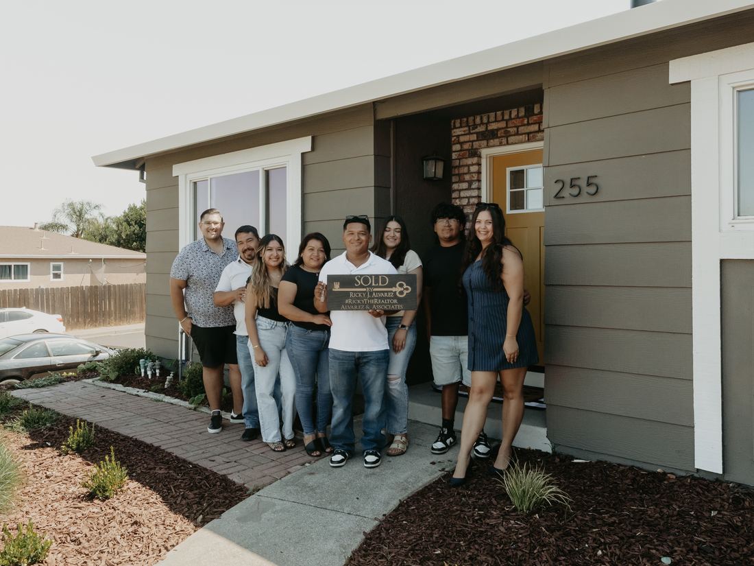 Family and friends gathered outside a new home