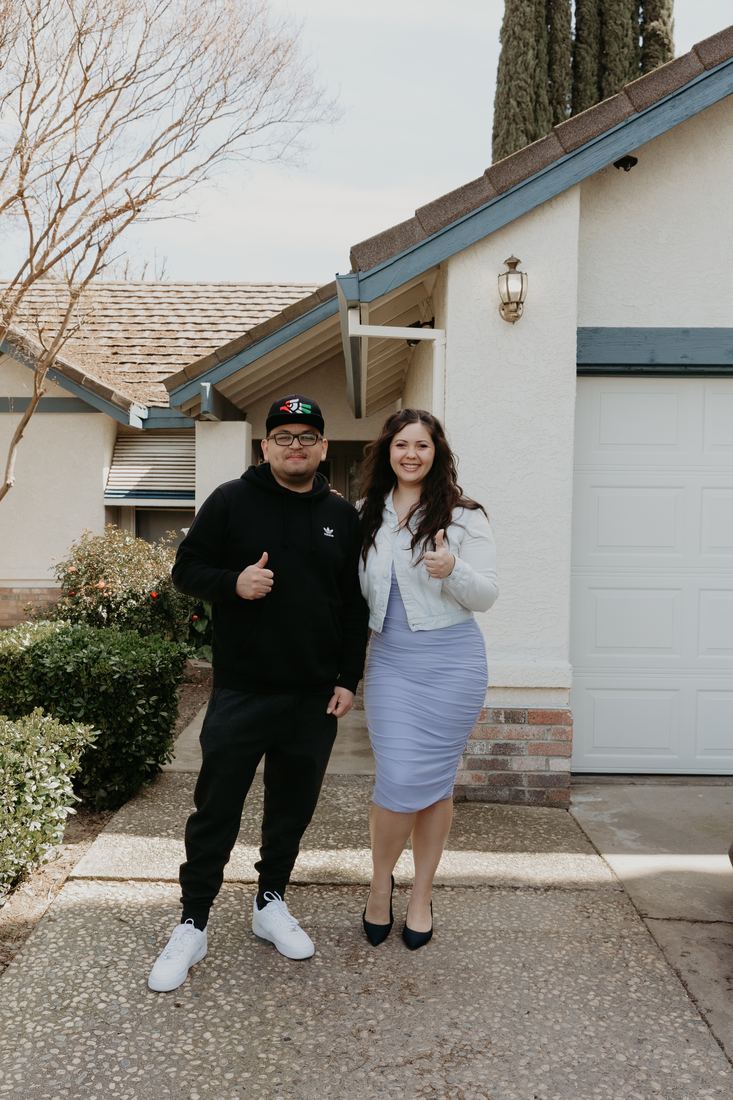 Couple in the front yard of their new home
