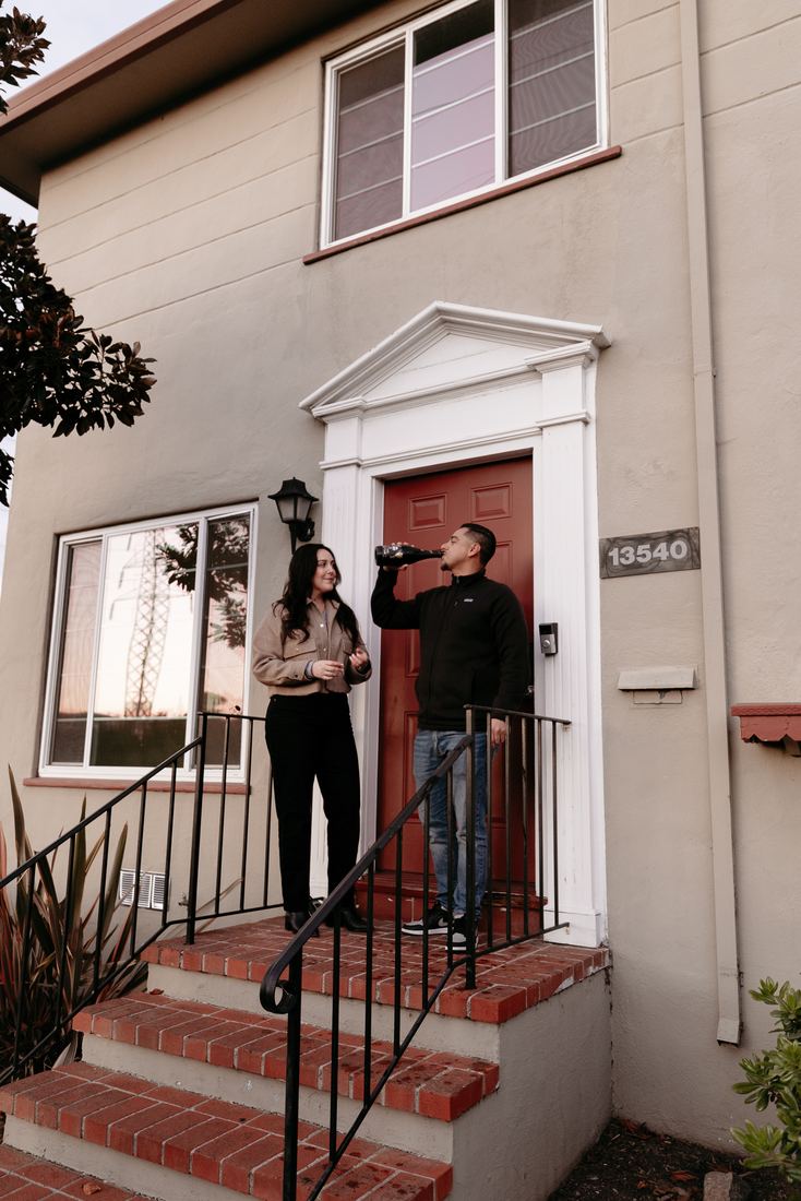 Couple on the front steps of their new home