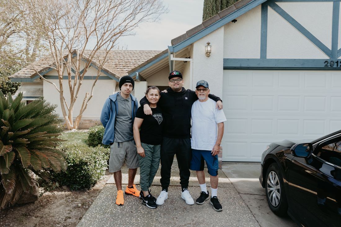 Family celebrating outside their new home