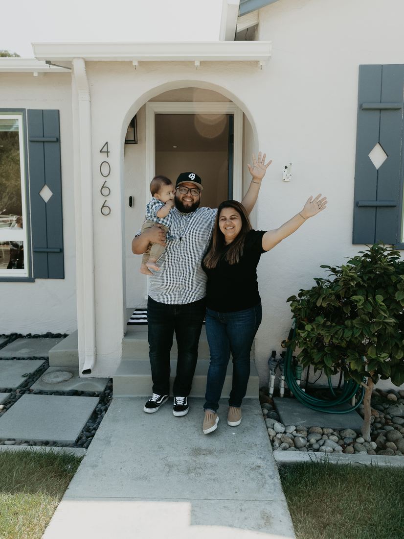 Family celebrating outside their new front door