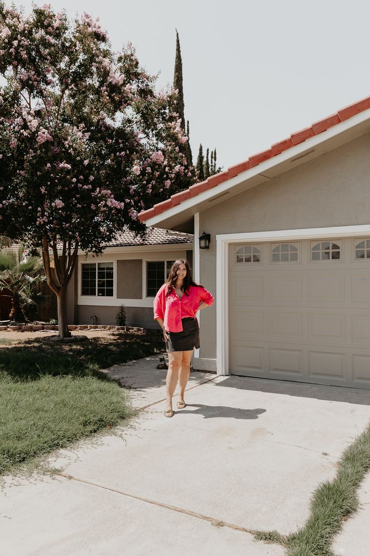 Buyer in the driveway of her new home