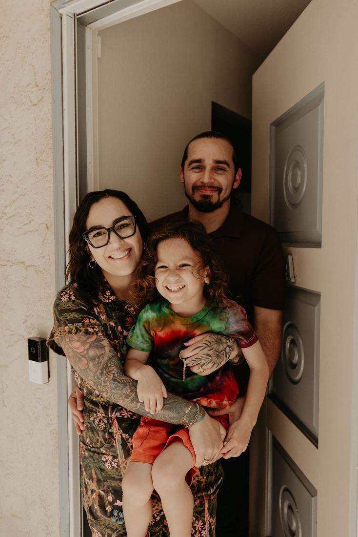 Couple with their child at the door of their new home