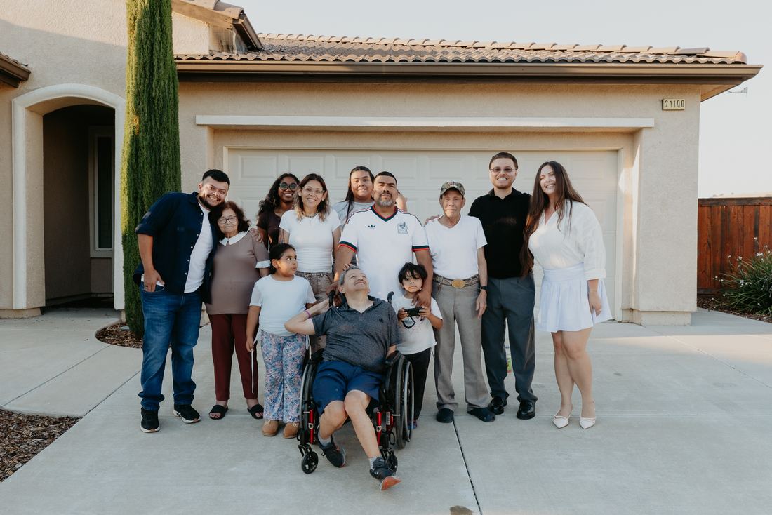 Extended family in front of their new home