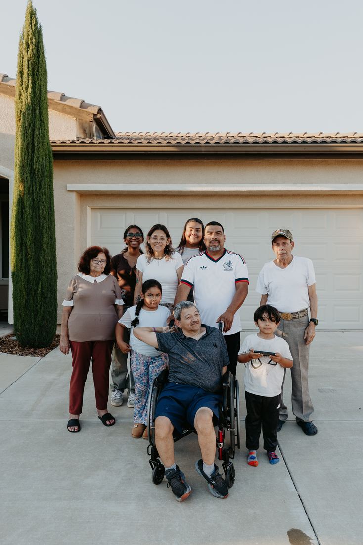 Extended family celebrating a closing in the driveway