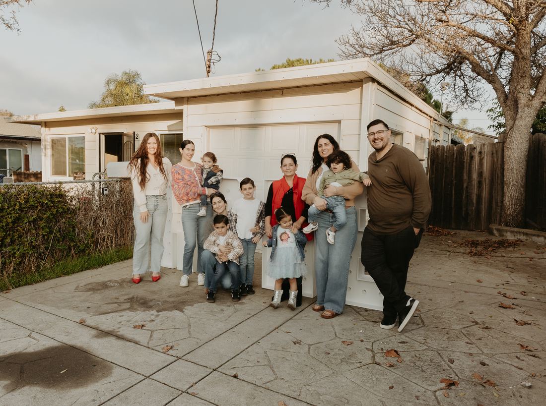 Family celebrating outside their new home