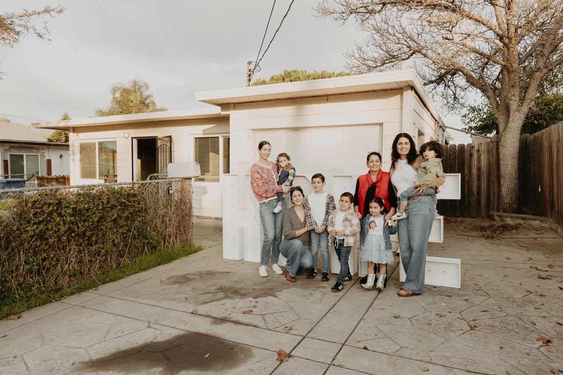 Family gathered outside their new home