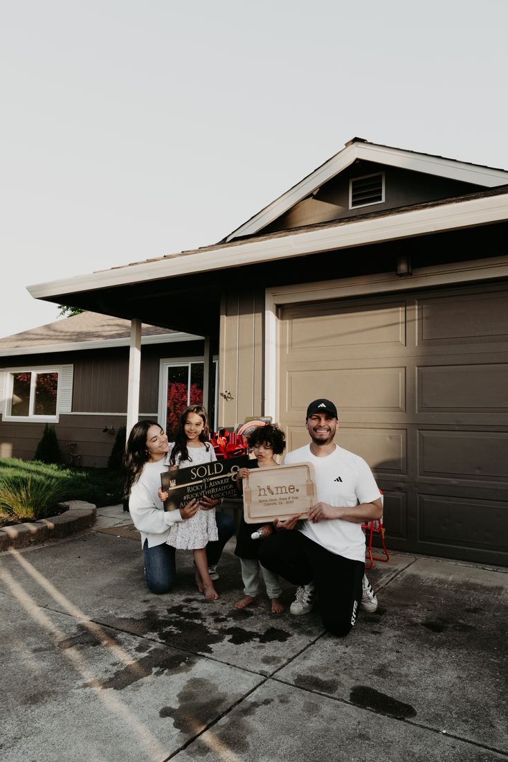 Family celebrating in front of their new home