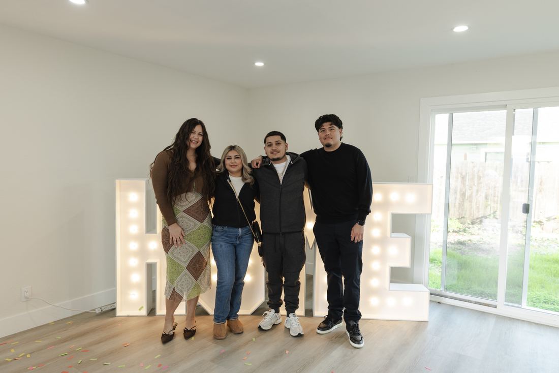 Family with HOME letters in their new home