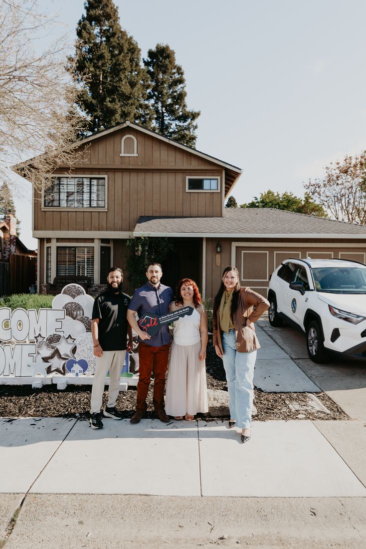 Family celebrating in front of their new home